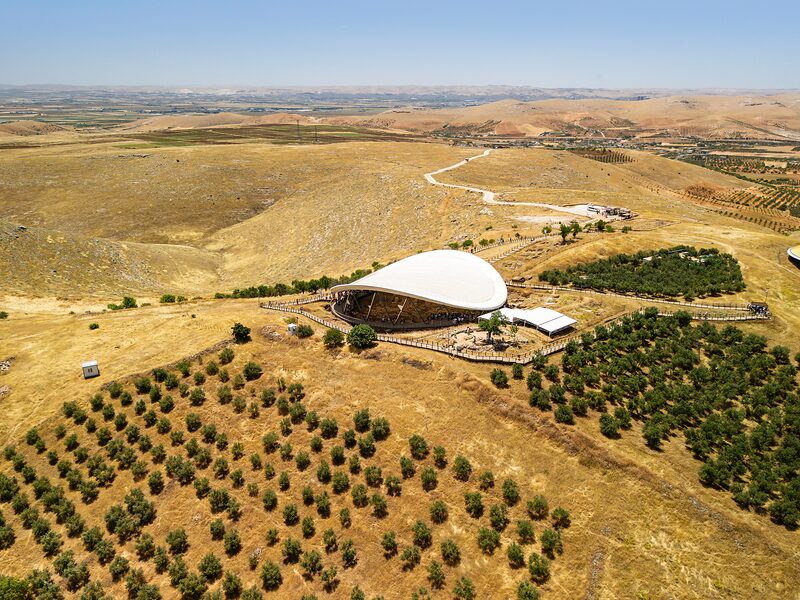 Göbeklitepe from the air: the excavation shelter on its limestone ridge, orchards and fields around it