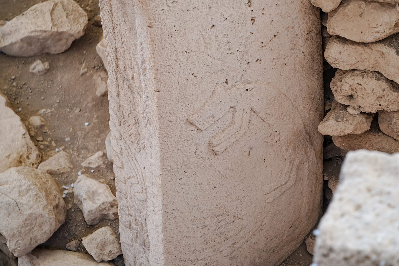Hands carved in low relief meeting on the front of a central pillar