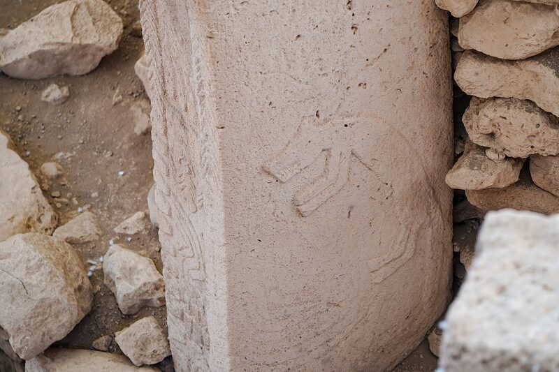 Hands carved in low relief meeting on the front of a central pillar
